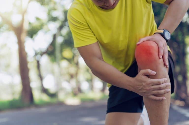A runner suffers from knee pain while out jogging